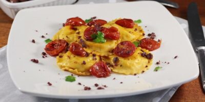 Ravioli Ricotta e peperoni con pomodorini confit e pesto